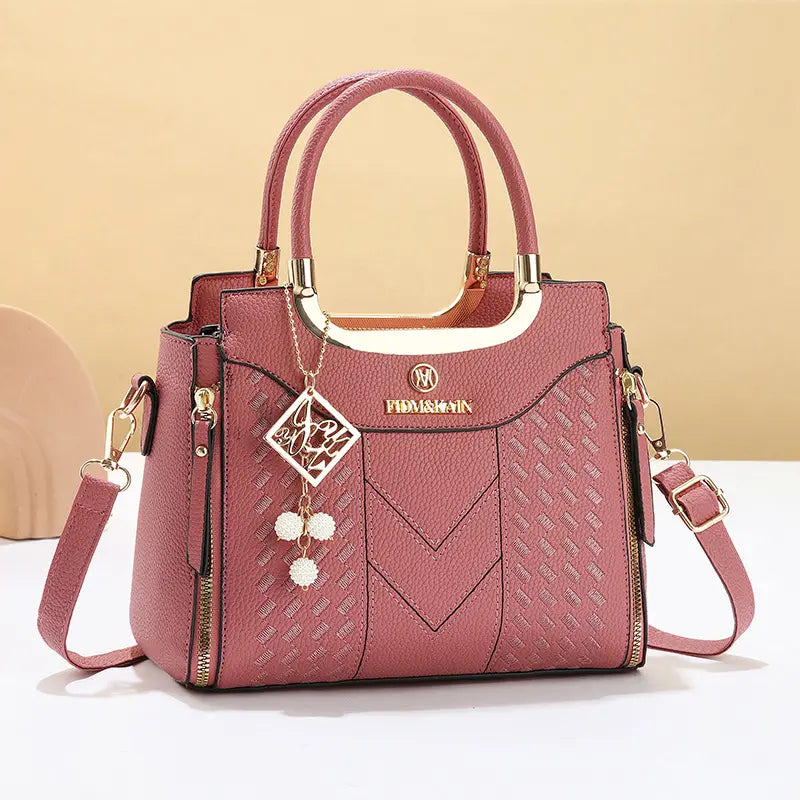 Bolso bandolera para mujer con costuras en forma de V, herrajes dorados, múltiples compartimentos y asa superior.